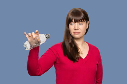 Woman in a red shirt holding a plastic bottle against a blue background
